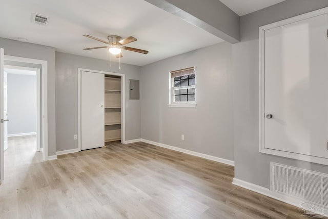 unfurnished bedroom featuring ceiling fan, electric panel, and light wood-type flooring