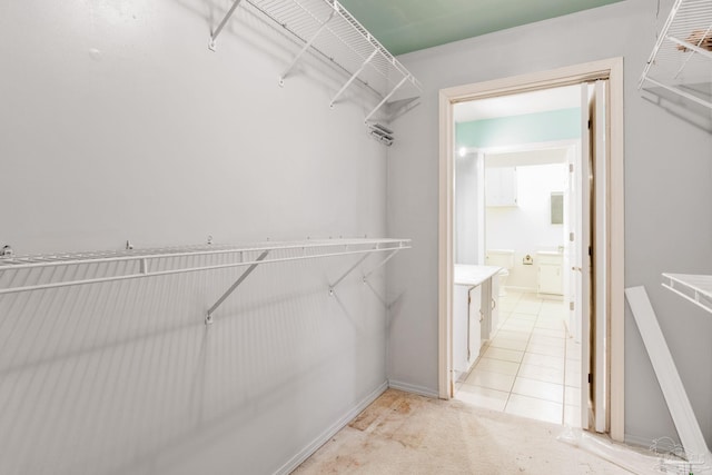 walk in closet featuring light tile patterned flooring