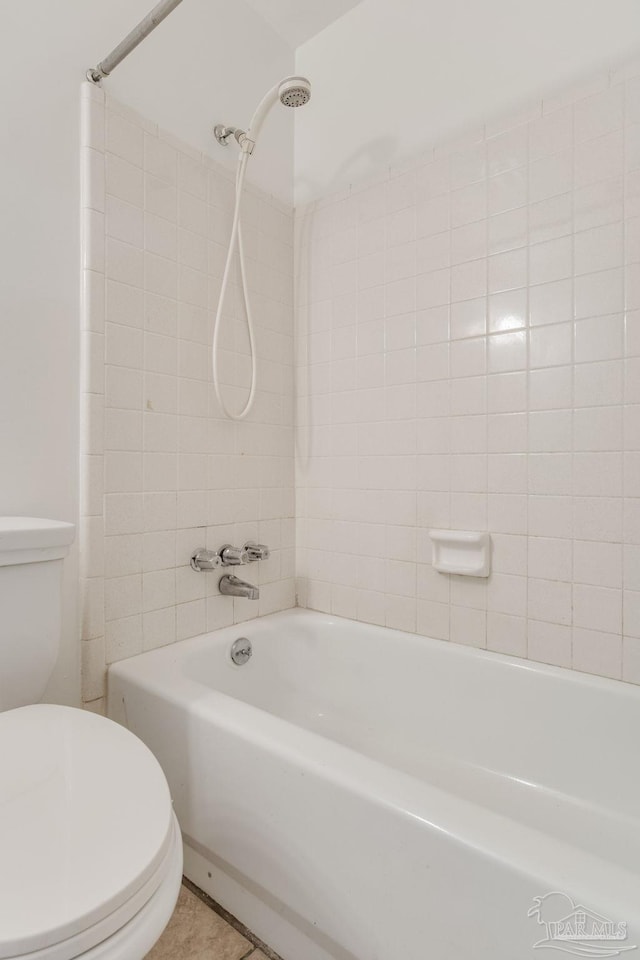 bathroom with toilet, tiled shower / bath combo, and tile patterned floors