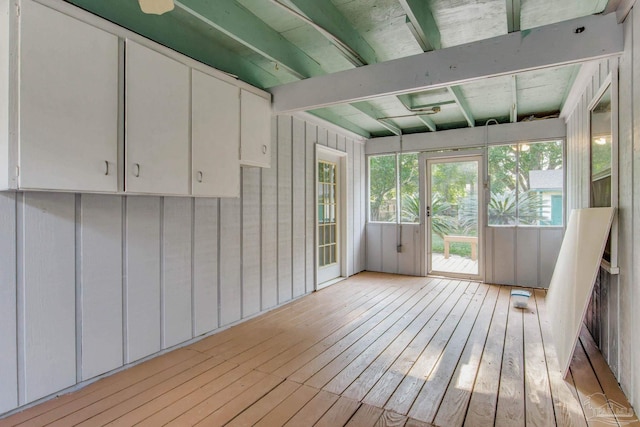 unfurnished sunroom featuring beamed ceiling