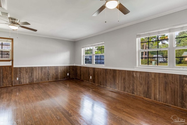 unfurnished room featuring ceiling fan, hardwood / wood-style floors, crown molding, and a healthy amount of sunlight