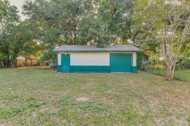 view of outdoor structure with a garage and a lawn