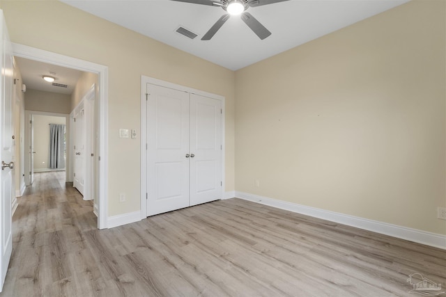 unfurnished bedroom with ceiling fan, light hardwood / wood-style flooring, and a closet