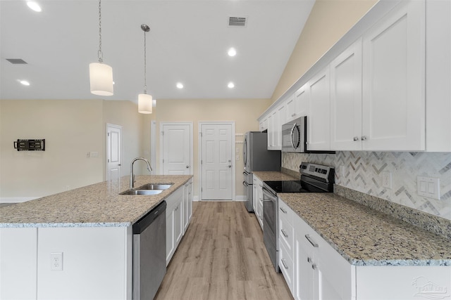 kitchen featuring pendant lighting, stainless steel appliances, an island with sink, white cabinets, and sink