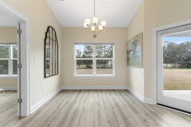 unfurnished dining area featuring a notable chandelier and light wood-type flooring