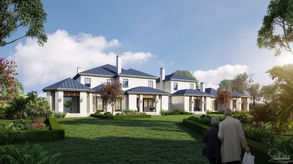rear view of house with a standing seam roof, a lawn, a chimney, and metal roof