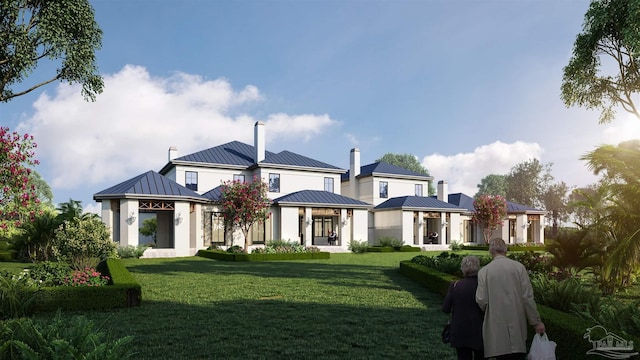 rear view of house with a standing seam roof, a lawn, a chimney, and metal roof