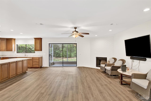 1118 Tall Pine Trl, Gulf Breeze, FL 32561 - living area featuring light wood-type flooring, a ceiling fan, recessed lighting, and a brick fireplace