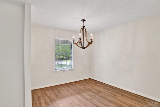 1118 Tall Pine Trl, Gulf Breeze, FL 32561 - empty room featuring a chandelier, wood finished floors, and baseboards