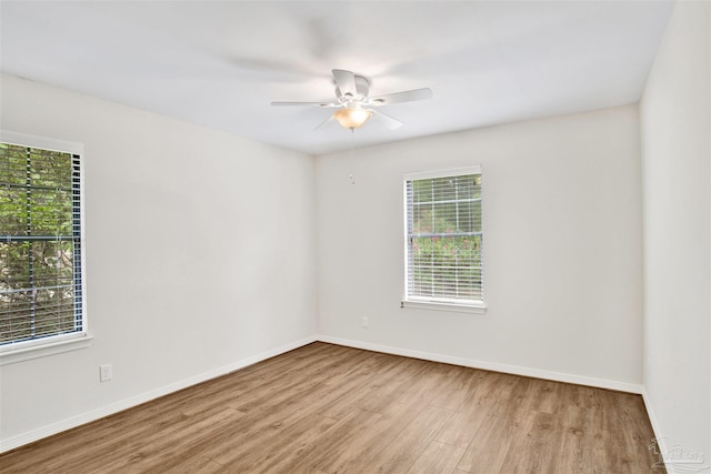 1118 Tall Pine Trl, Gulf Breeze, FL 32561 - unfurnished room featuring healthy amount of natural light, wood finished floors, a ceiling fan, and baseboards