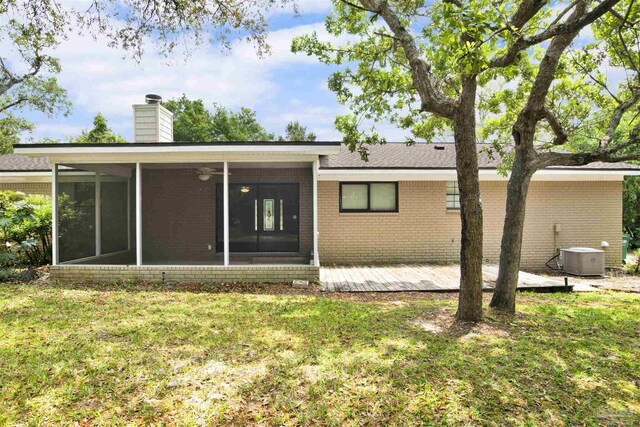 1118 Tall Pine Trl, Gulf Breeze, FL 32561 - back of house featuring a sunroom, brick siding, central AC unit, a yard, and a chimney