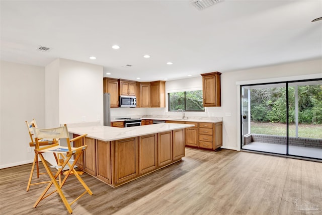 1118 Tall Pine Trl, Gulf Breeze, FL 32561 - kitchen featuring appliances with stainless steel finishes, light wood-style flooring, a sink, a peninsula, and recessed lighting