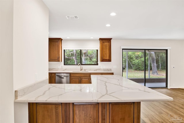 1118 Tall Pine Trl, Gulf Breeze, FL 32561 - kitchen featuring a sink, a peninsula, brown cabinets, light stone countertops, and recessed lighting