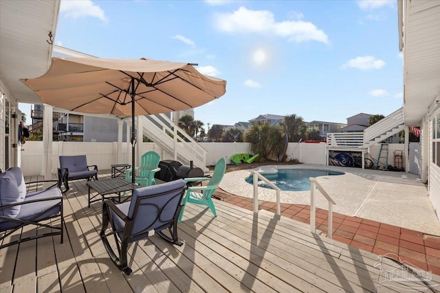 wooden deck featuring a fenced in pool and a patio area