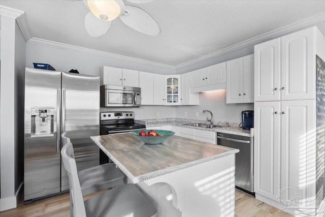 kitchen featuring a center island, white cabinets, sink, ceiling fan, and appliances with stainless steel finishes