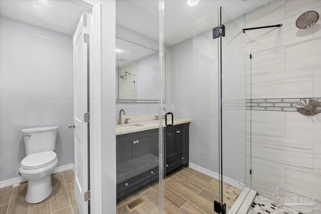 bathroom featuring walk in shower, vanity, and toilet