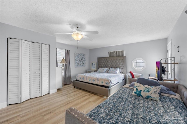 bedroom featuring ceiling fan, light wood-type flooring, and a textured ceiling