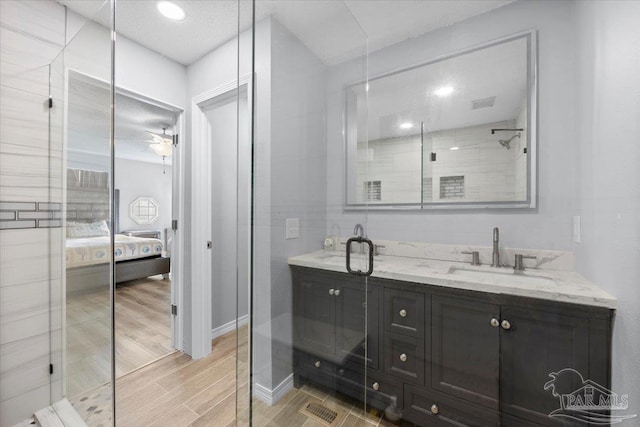 bathroom featuring walk in shower, ceiling fan, and sink