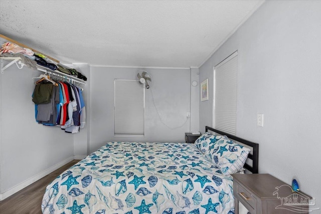 bedroom with a closet, dark hardwood / wood-style floors, and a textured ceiling