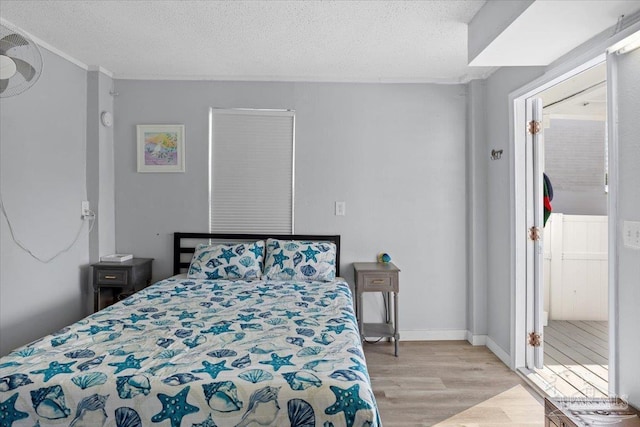 bedroom with light hardwood / wood-style floors and a textured ceiling