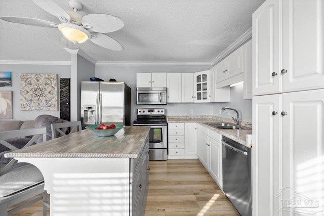 kitchen with white cabinets, sink, a center island, and appliances with stainless steel finishes