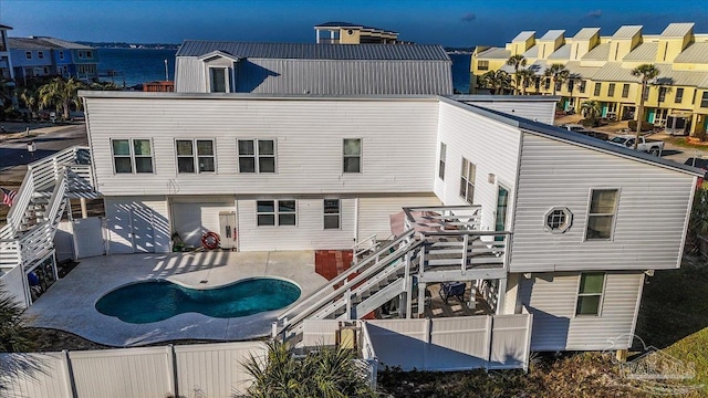 rear view of property featuring a patio area and a water view