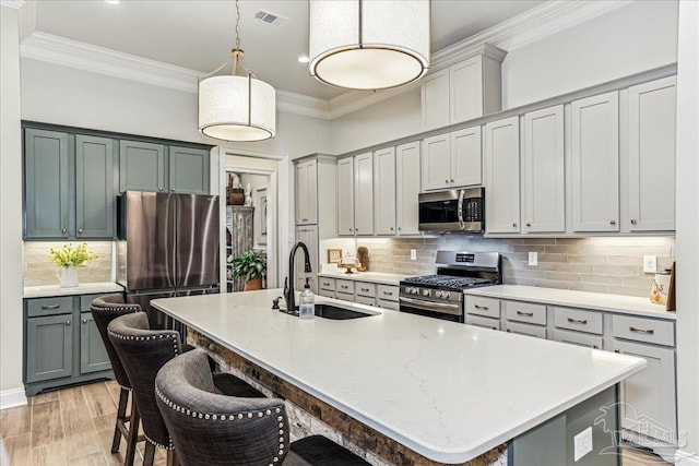 3160 Mountain Laurel Trl, Cantonment, FL 32533 - kitchen with stainless steel appliances, tasteful backsplash, crown molding, a kitchen bar, and decorative light fixtures