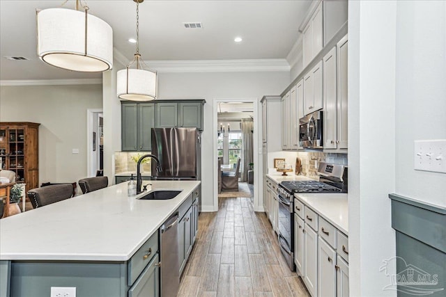 3160 Mountain Laurel Trl, Cantonment, FL 32533 - kitchen with appliances with stainless steel finishes, gray cabinets, ornamental molding, decorative backsplash, and light countertops