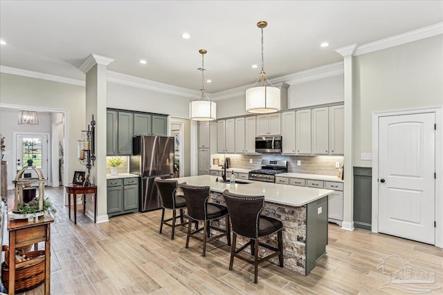 3160 Mountain Laurel Trl, Cantonment, FL 32533 - kitchen featuring appliances with stainless steel finishes, light countertops, a kitchen breakfast bar, gray cabinetry, and tasteful backsplash