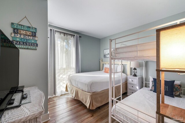 bedroom featuring multiple windows and hardwood / wood-style flooring