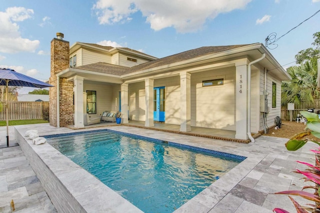 rear view of house with a patio area and a fenced in pool