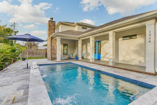 view of swimming pool featuring pool water feature and a patio