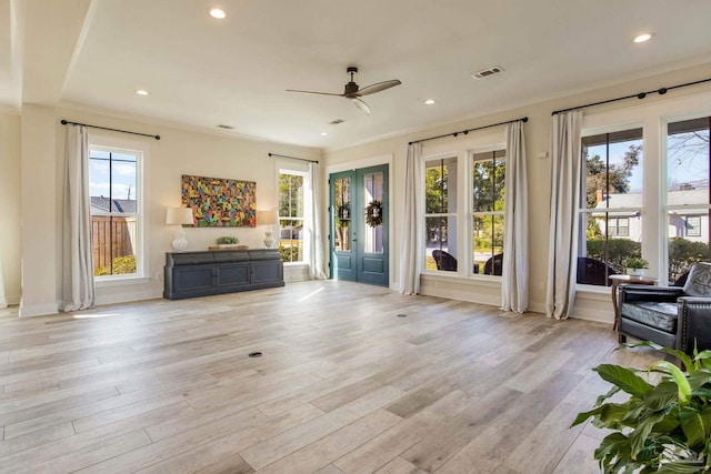 unfurnished living room featuring ceiling fan, light hardwood / wood-style flooring, and ornamental molding