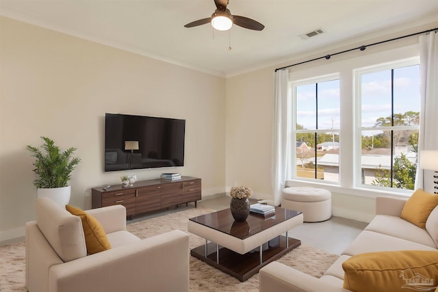 living room featuring crown molding, ceiling fan, and a healthy amount of sunlight