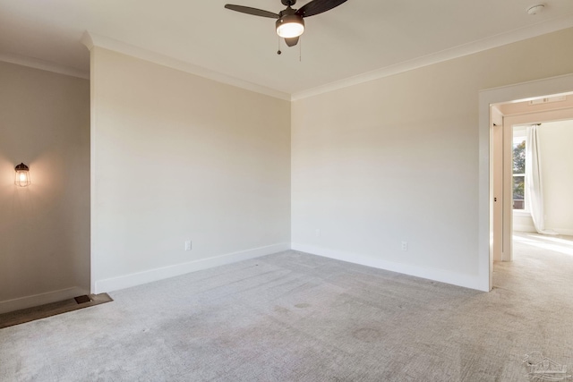 carpeted spare room with ceiling fan and crown molding