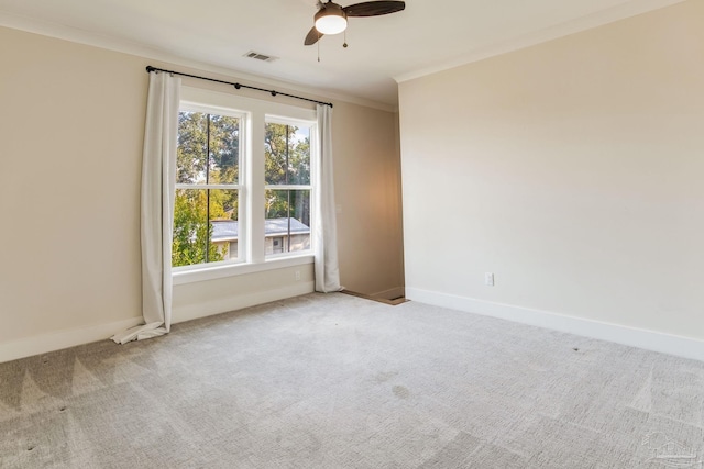 carpeted spare room with ceiling fan and ornamental molding