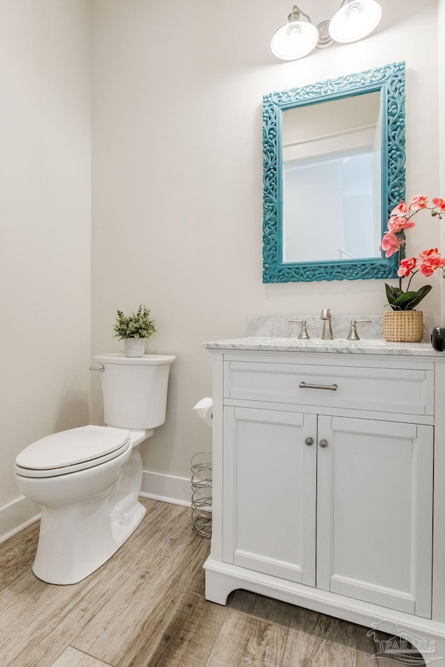 bathroom with vanity, hardwood / wood-style flooring, and toilet