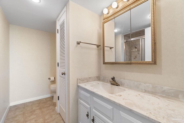 bathroom featuring tile patterned floors, toilet, vanity, and an enclosed shower