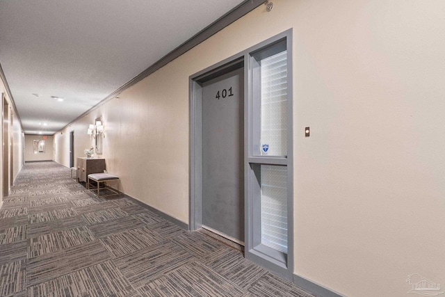 hallway with dark carpet and ornamental molding