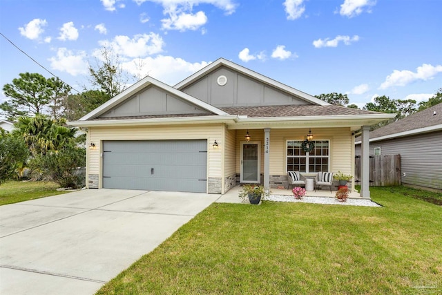 view of front of property featuring a porch, a garage, and a front lawn