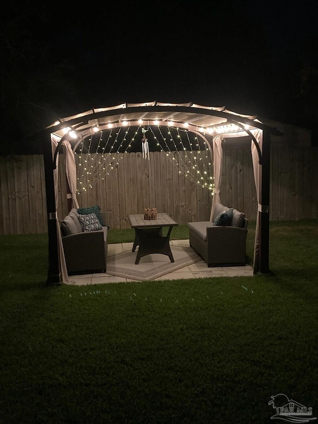 patio at night with a lawn and a pergola