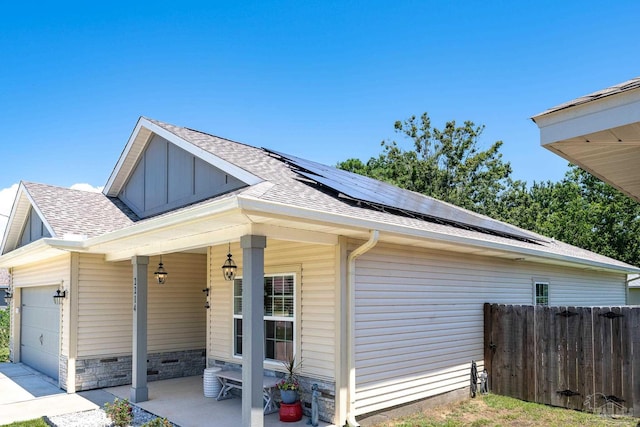 view of property exterior featuring solar panels and a garage