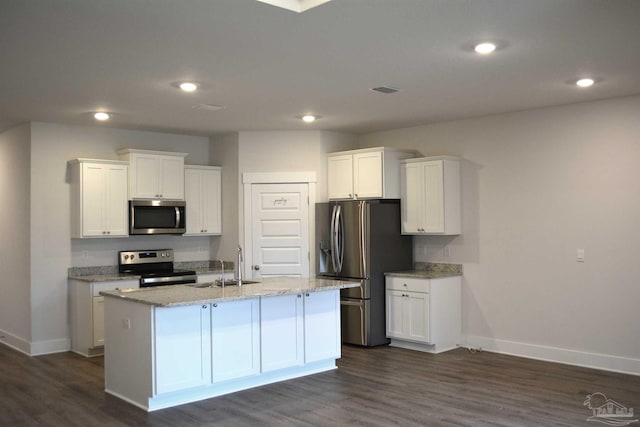 kitchen with dark hardwood / wood-style flooring, appliances with stainless steel finishes, and an island with sink