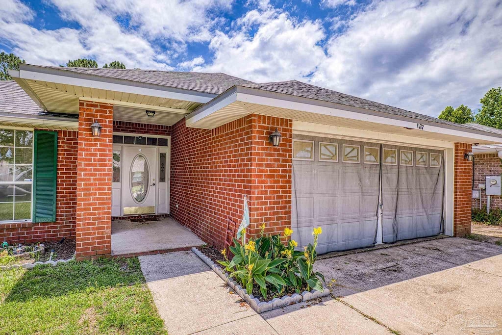 1177 Sterling Point Pl, Gulf Breeze, FL 32563 - entrance to property featuring an attached garage, brick siding, driveway, and roof with shingles