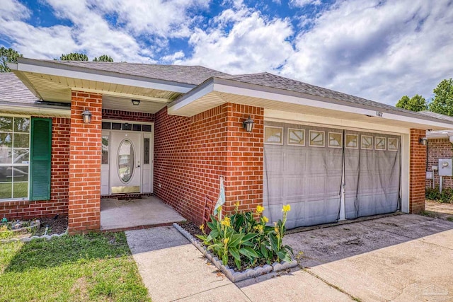 1177 Sterling Point Pl, Gulf Breeze, FL 32563 - entrance to property featuring an attached garage, brick siding, driveway, and roof with shingles