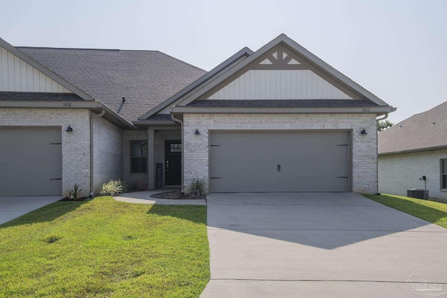 view of front facade with cooling unit, a garage, and a front yard