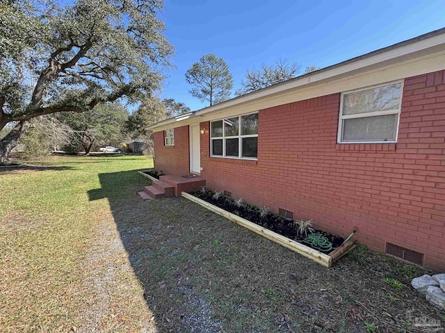 view of property exterior featuring crawl space, a lawn, and brick siding