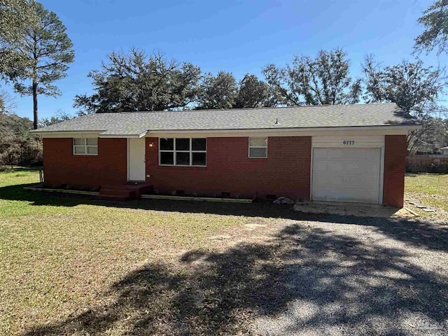 ranch-style home with a garage, brick siding, and a front yard