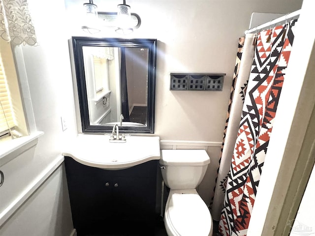 full bathroom with wainscoting, toilet, vanity, and a shower with curtain