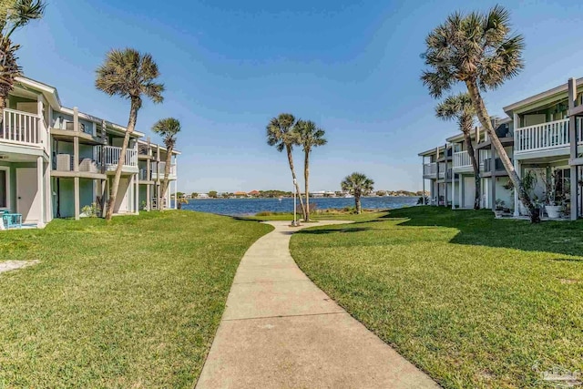 view of community with a yard and a water view